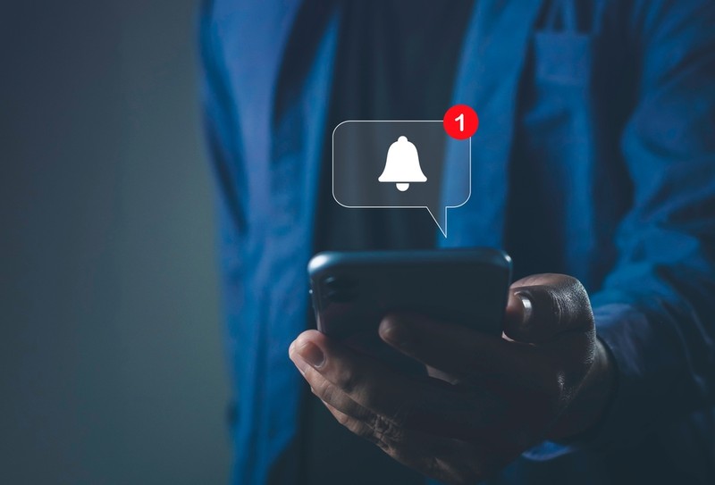 Man Holding Phone with Bell Notification Icon