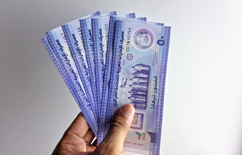 Hand Holding 50 Dirham Banknotes