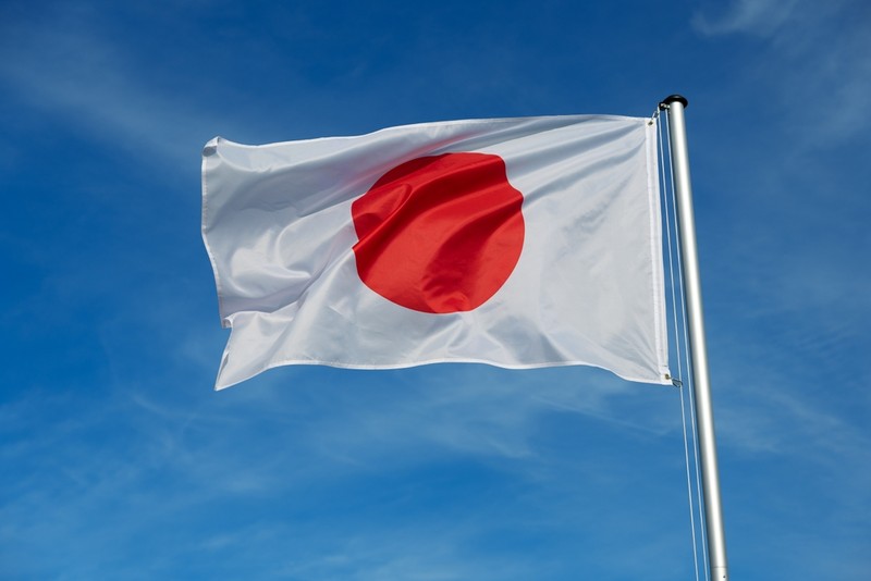 Japan Flag on Pole Against Blue Sky